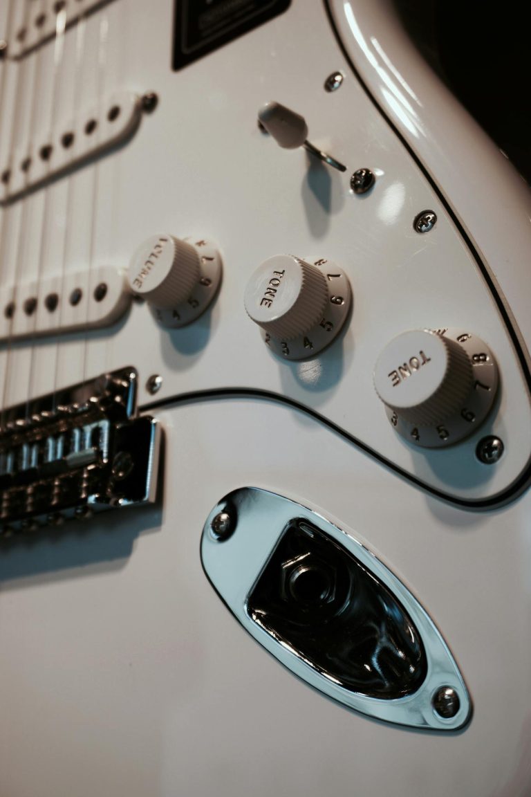 Detailed view of an electric guitar's knobs and controls highlighting craftsmanship.